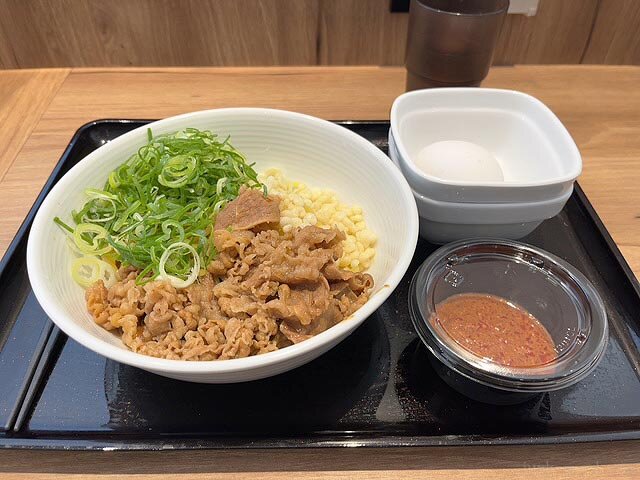 吉野家の牛玉スタミナまぜそば店舗用 にんにくマシマシだれと半熟卵は別容器 撮影：junk-word.com